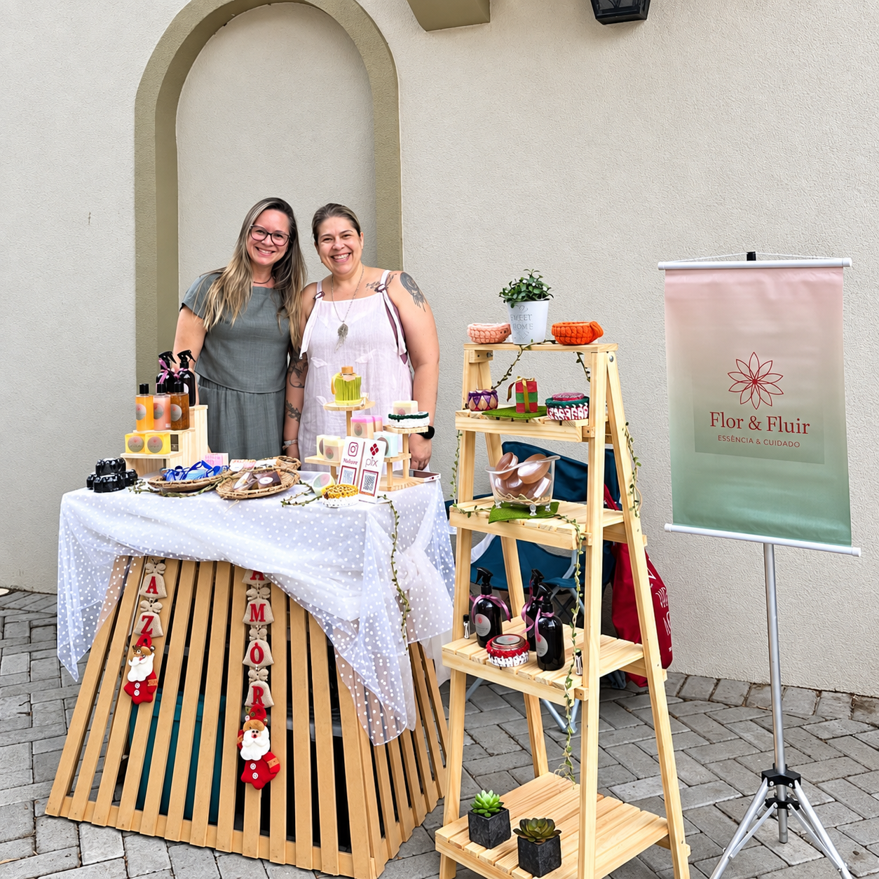 Duas mulheres junto à exposição de produtos Flor & Fluir